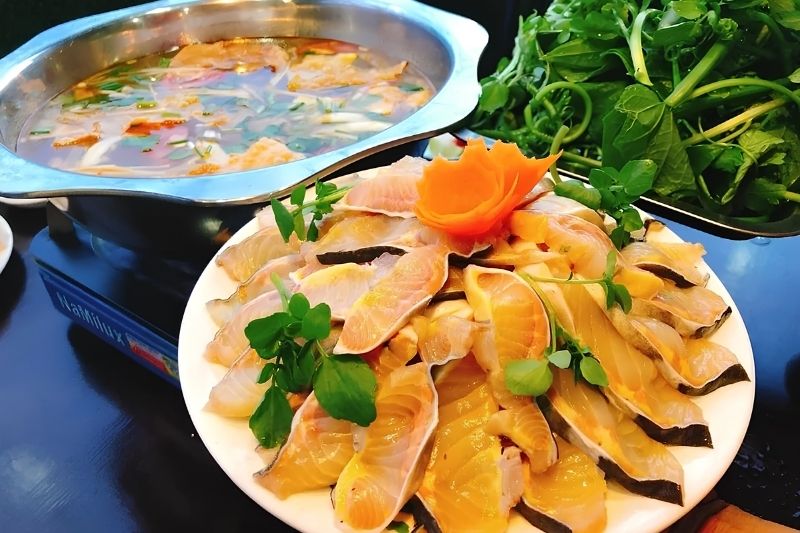 Sapa Salmon & Sturgeon Hotpot: Fresh Cold-Water Seafood A beautiful plate of thinly sliced, bright orange fresh salmon ready to be dipped into a steaming mountain hotpot broth in Sapa.