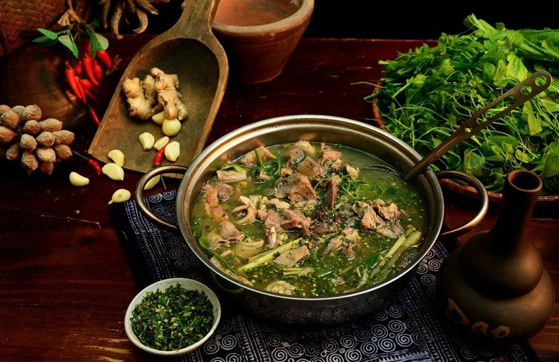 Thang Co Sapa: Inside the Famous High-Altitude Food Challenge A large, simmering rustic pot of traditional Thang Co soup featuring sliced meat and aromatic highland herbs in a Sapa market.