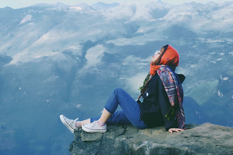 Traveler sitting on the photo rock of the Ha Giang Skywalk at Ma Pi Leng