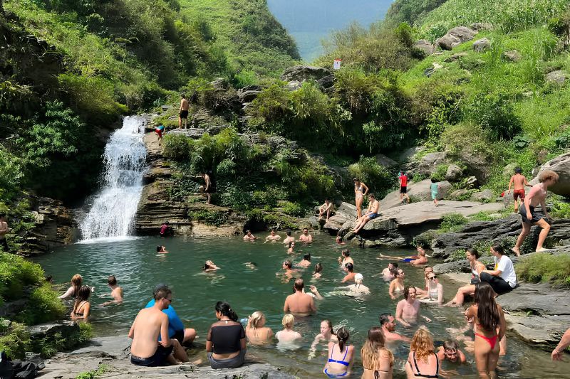 Swimmers in the pool below Du Gia Waterfall