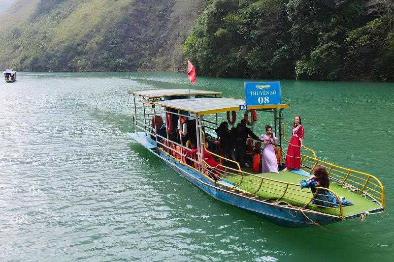 Sightseeing boat with passengers on the Nho Que River
